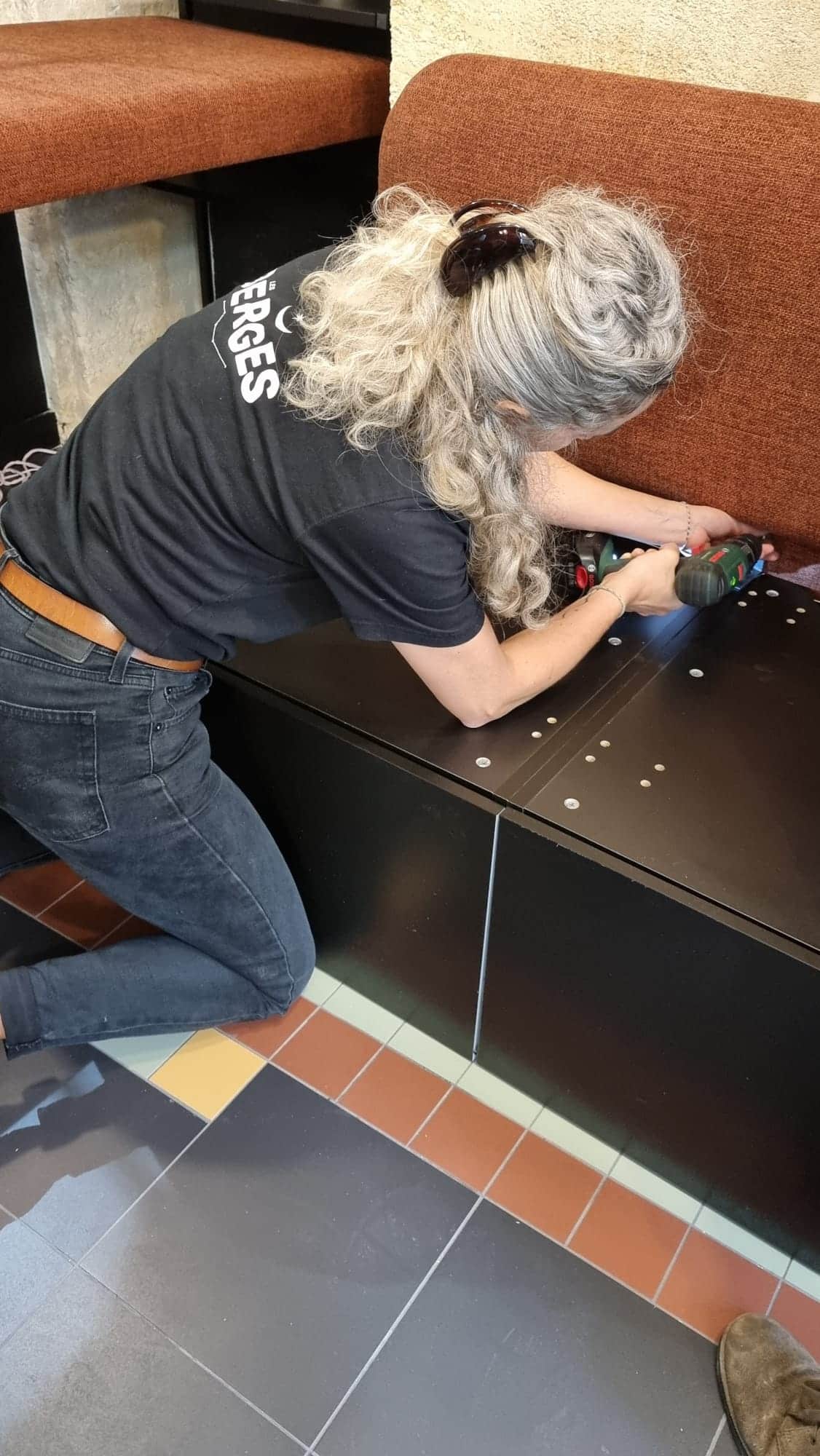 Cécile Jean en train d'installer une banquette chez Lalère.